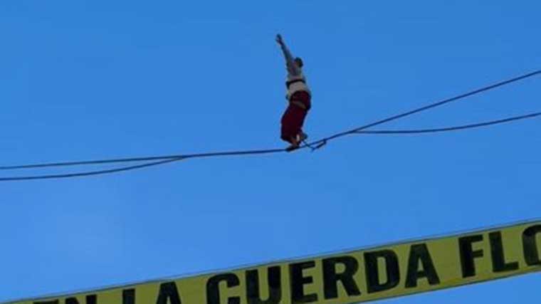 Un activista camina sobre una cuerda floja a 30 metros de altura en la Plaza de España para protestar