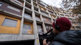 Un cámara de televisión graba el bloque de pisos donde se ha producido el doble asesinato, en la calle Jacobeo del barrio de Carabanchel