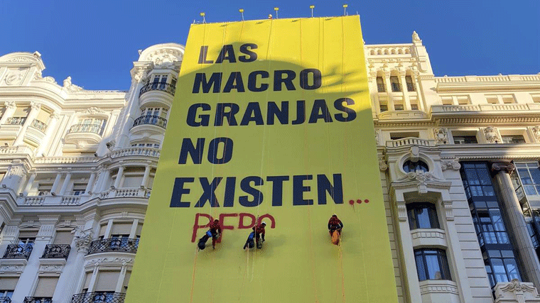 Escaladores de Greenpace exigen a Sánchez en Gran Vía el cierre de 'las macrogranjas'