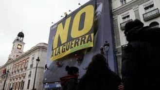 Greenpeace despliega una gran pancarta en la Puerta del Sol con un `No a la guerra´