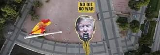 Greenpeace despliega en la Plaza de Colón una imagen gigante de Trump vomitando petróleo