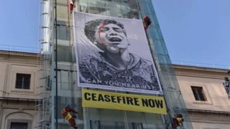Activistas cuelgan una pancarta en el Reina Sofía pidiendo el 'Alto el fuego ya'